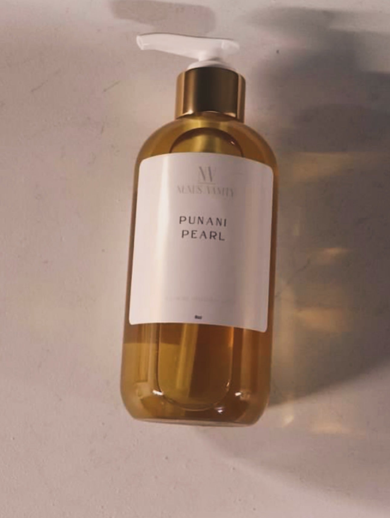Lotion bottle labeled 'Punani Pearl' on a neutral background